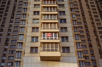 a tall building with windows and a red stop sign
