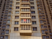 a tall building with windows and a red stop sign