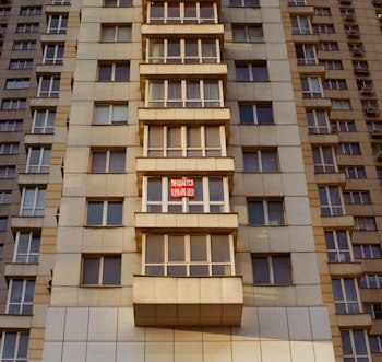 a tall building with windows and a red stop sign