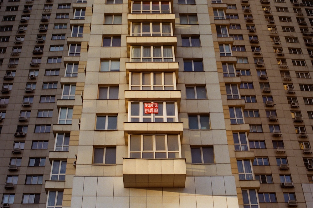 a tall building with windows and a red stop sign