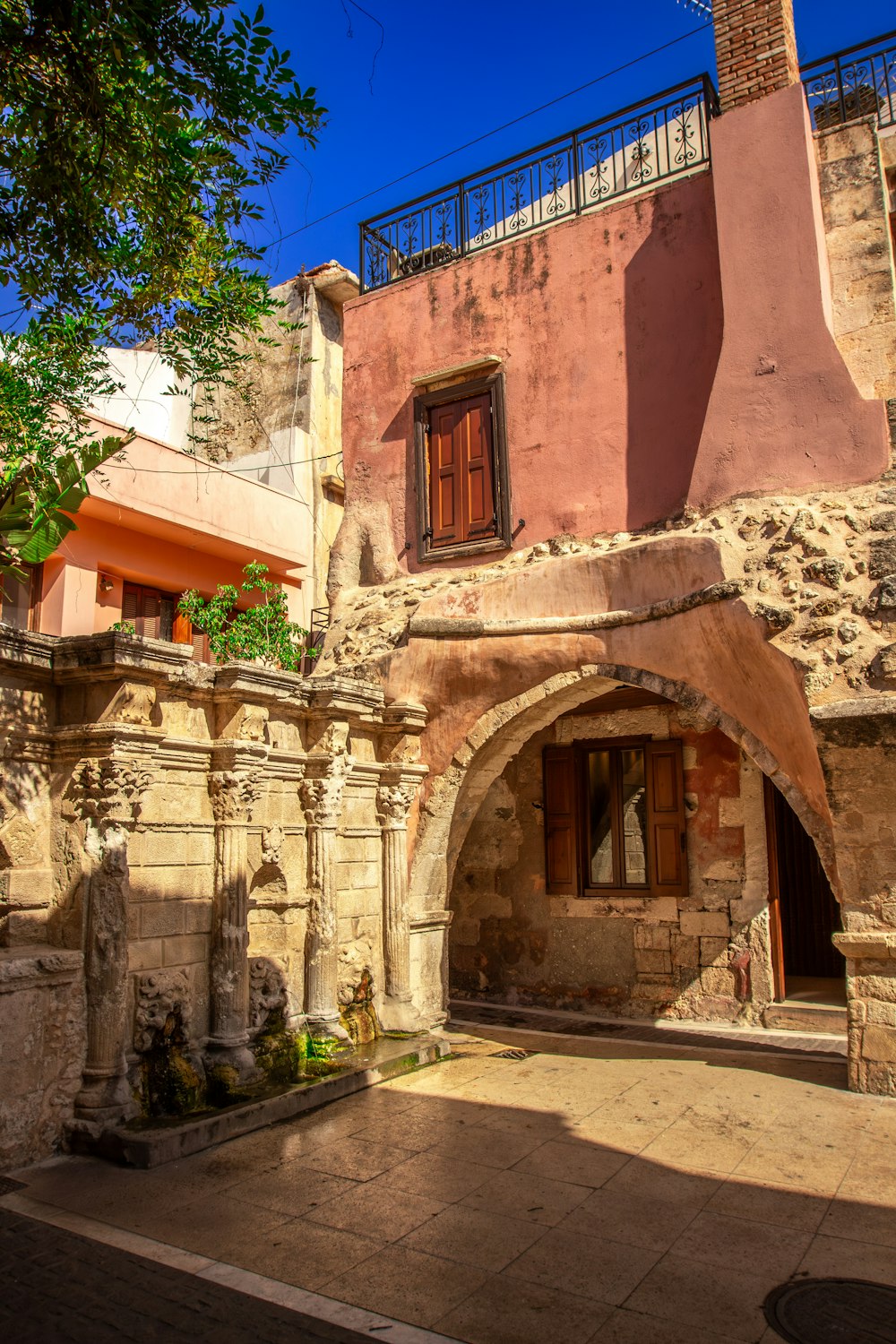 Un vecchio edificio con un cortile in pietra e un balcone