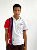 Model wearing a classic blue and red striped vintage football shirt on a sunny street.