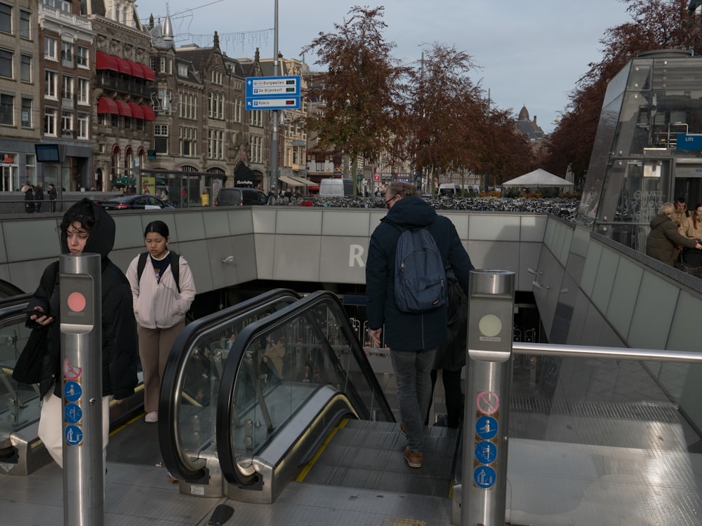 a group of people riding an escalator down a street