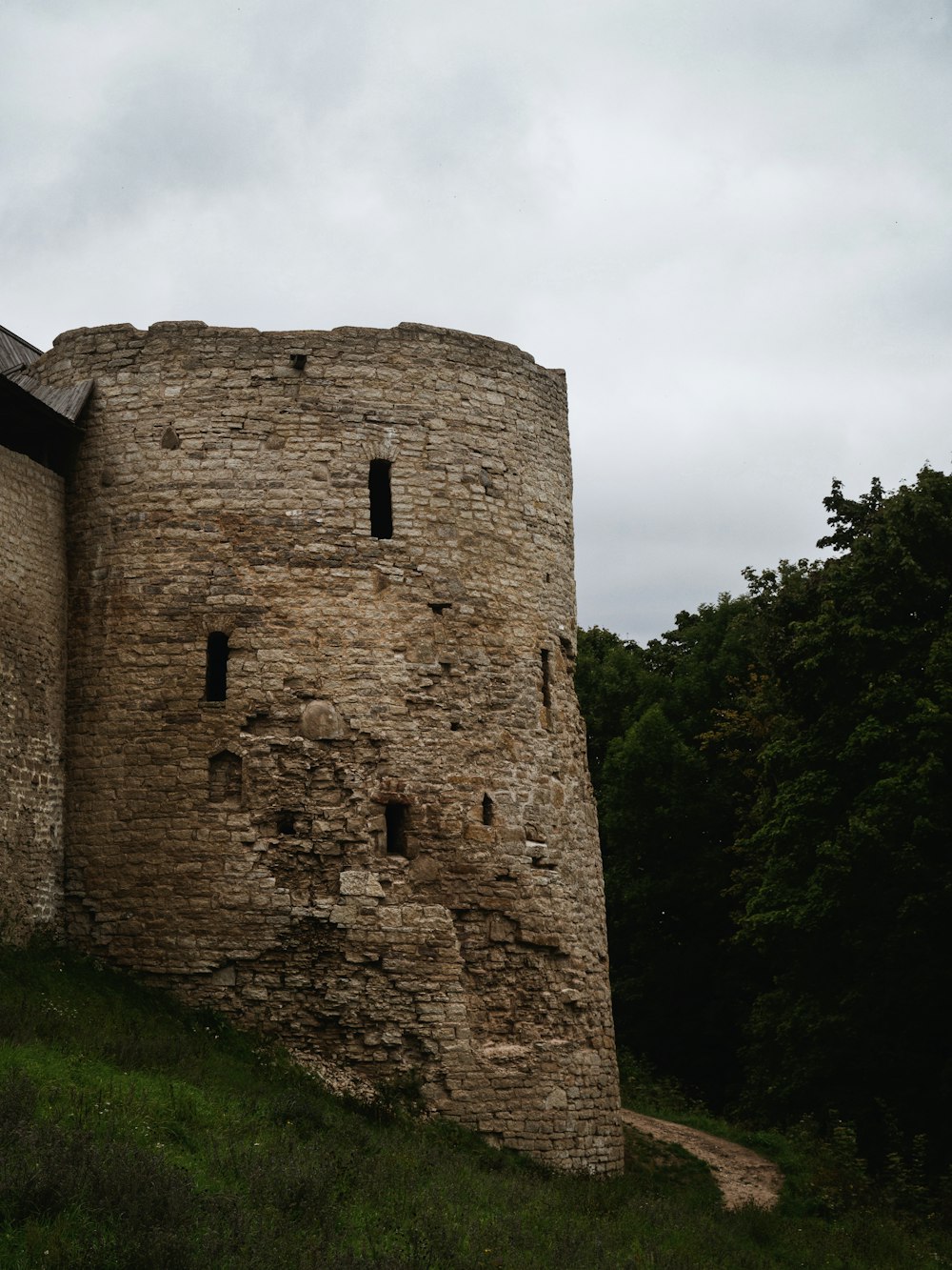 a stone tower with two windows on top of a hill