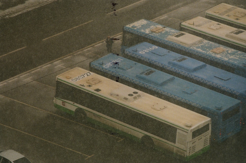 a group of buses parked next to each other in a parking lot