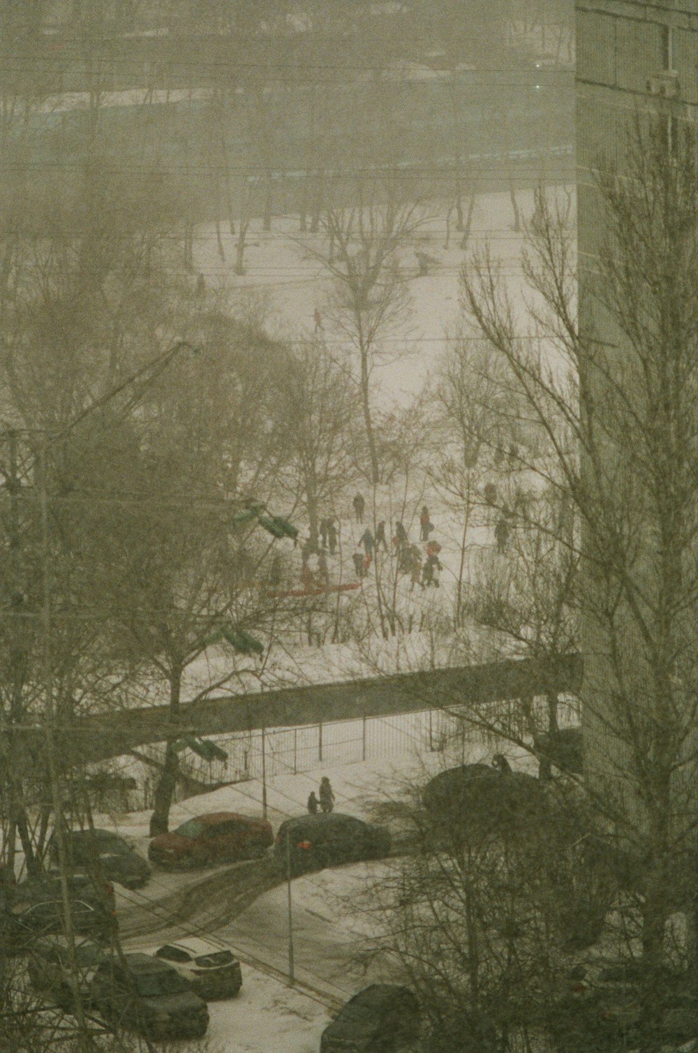 a group of people walking across a snow covered park