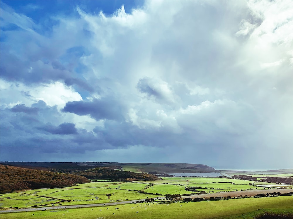 Blick auf ein saftig grünes Feld unter einem bewölkten Himmel