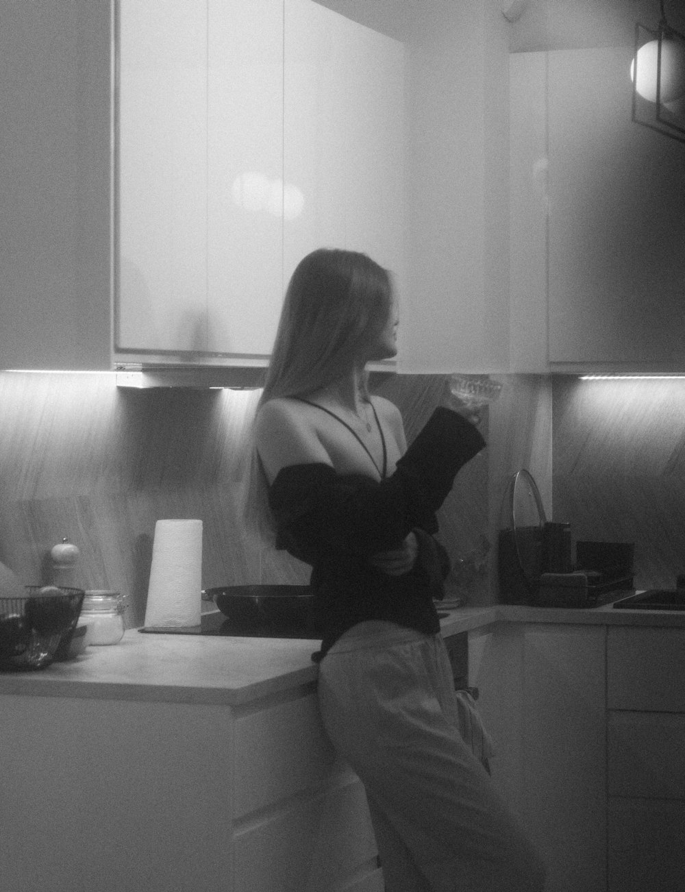 a woman sitting on a counter in a kitchen