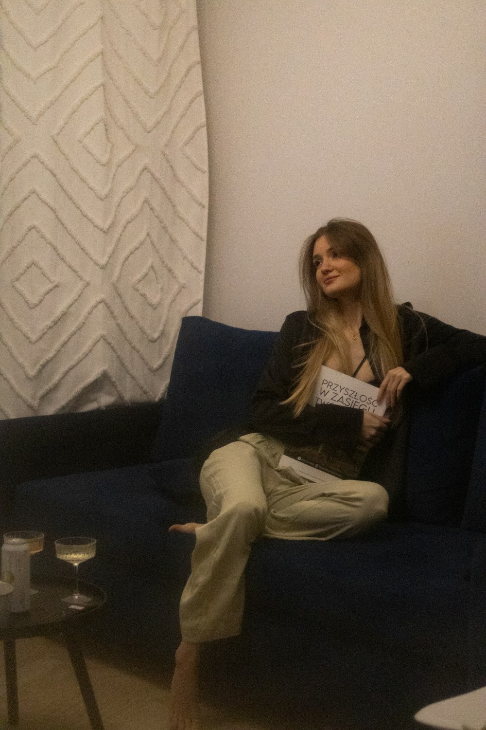 a woman sitting on a blue couch in a living room