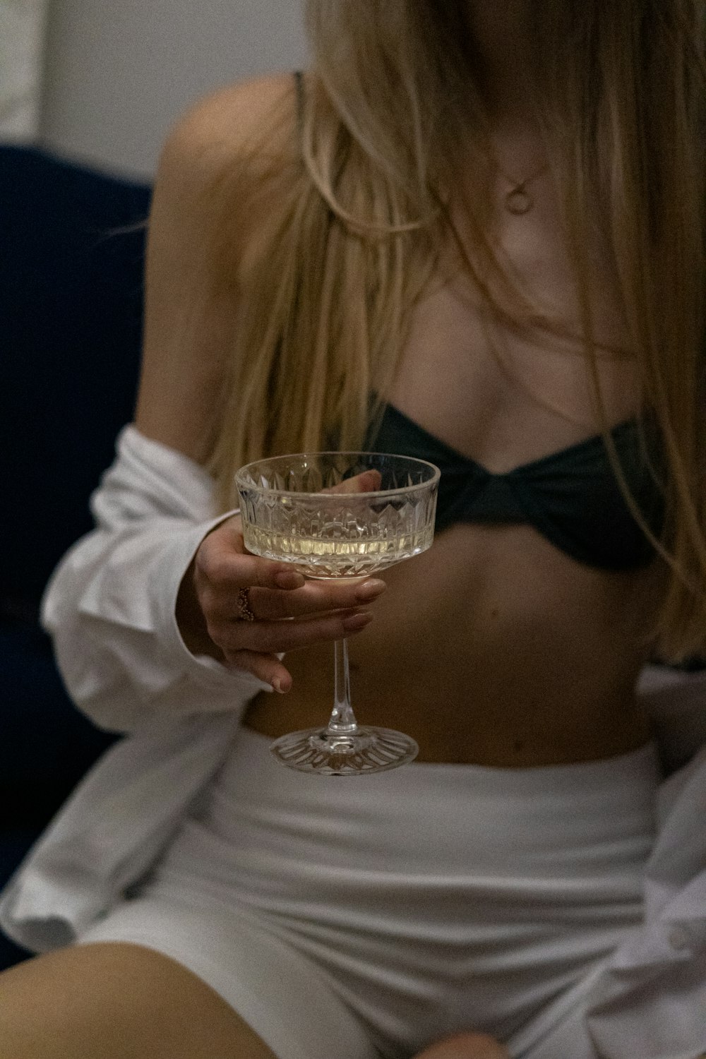 a woman sitting on a couch holding a wine glass