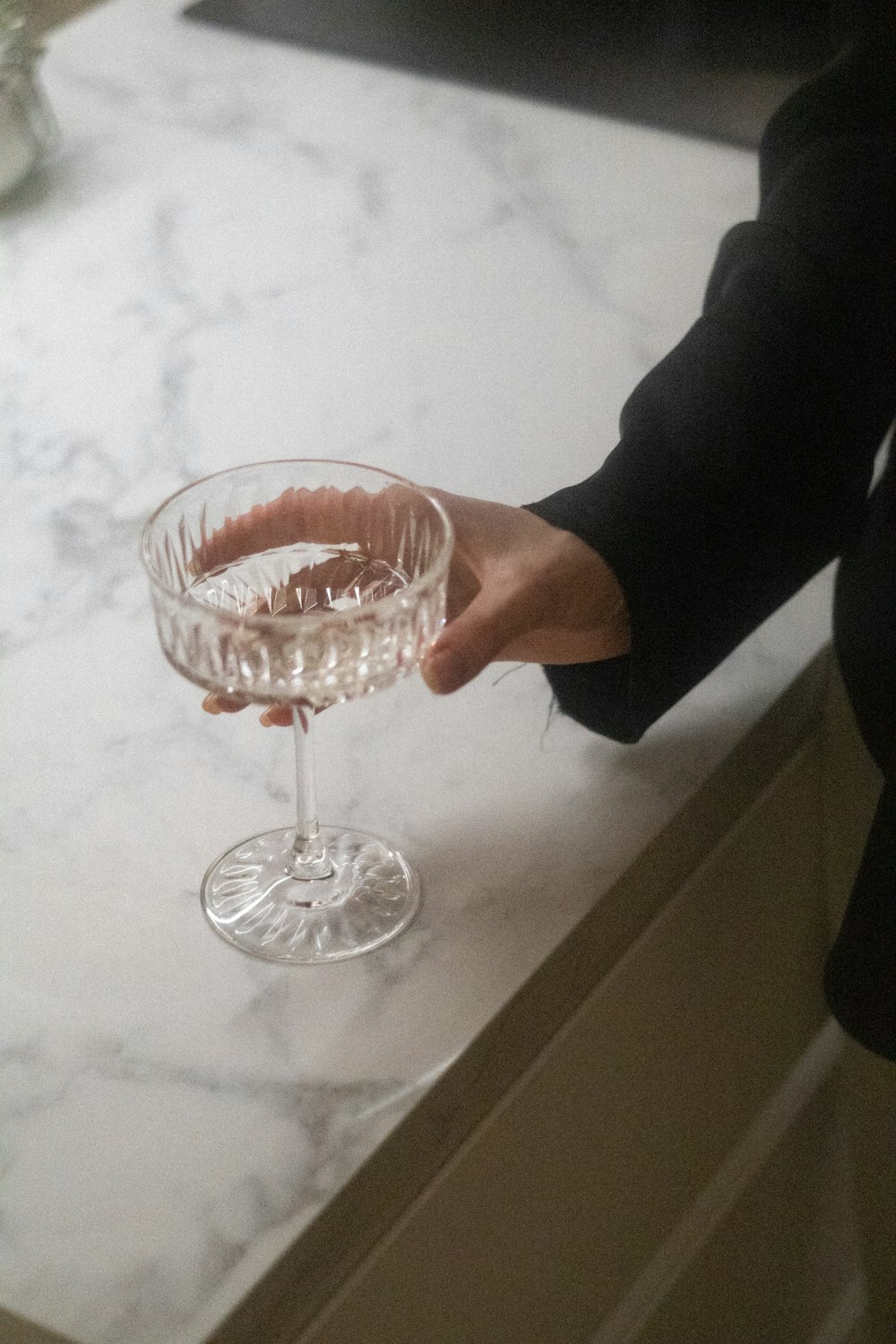 a person holding a wine glass on top of a counter