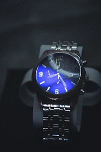 Stylish fossil blue gmt fs6092 watch featuring a blue dial, set against a moody dark stone background.