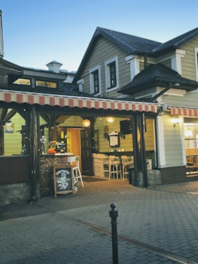 A welcoming restaurant entrance with wooden doors and a cozy outdoor seating area.