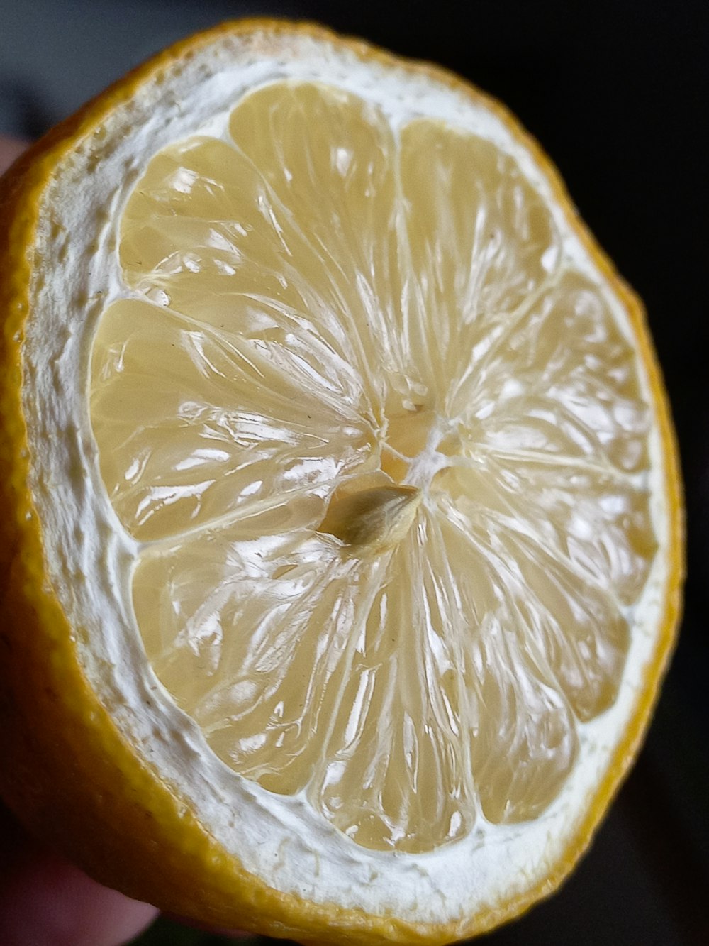 a close up of a person holding a half of a lemon