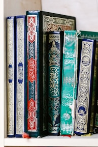 A vibrant display of colorful, handcrafted books on a wooden shelf.