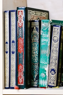 A colorful display of traditional Jewish books and prayer shawls on a shelf.