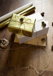 two wrapped presents sitting on top of a wooden table