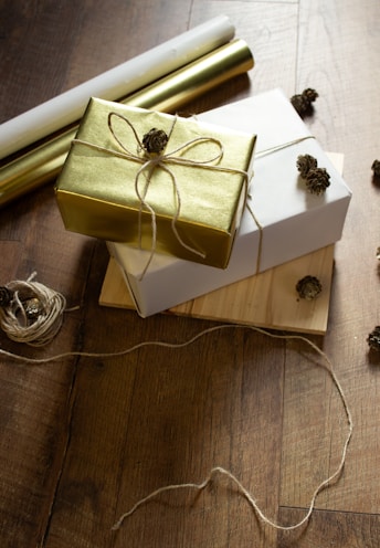 two wrapped presents sitting on top of a wooden table