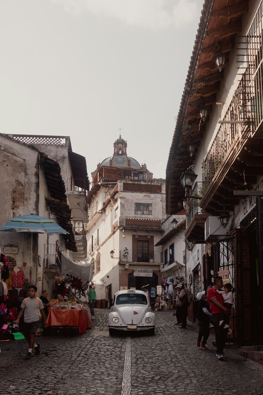 a car is parked on a cobblestone street