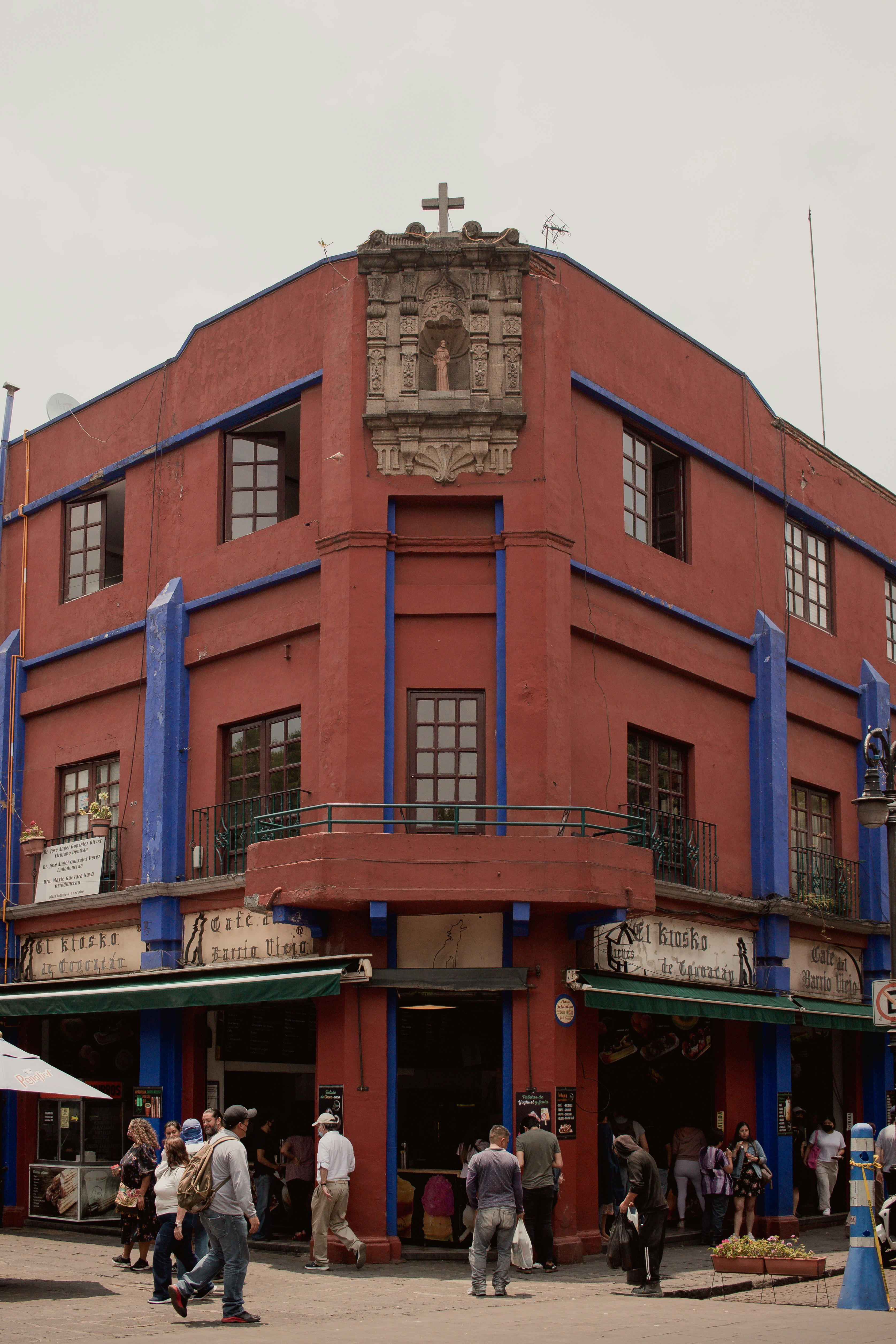 a group of people standing outside of a red building