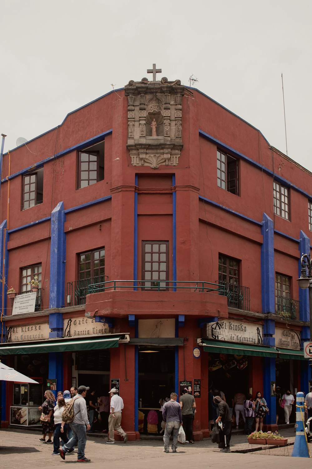 a group of people standing outside of a red building