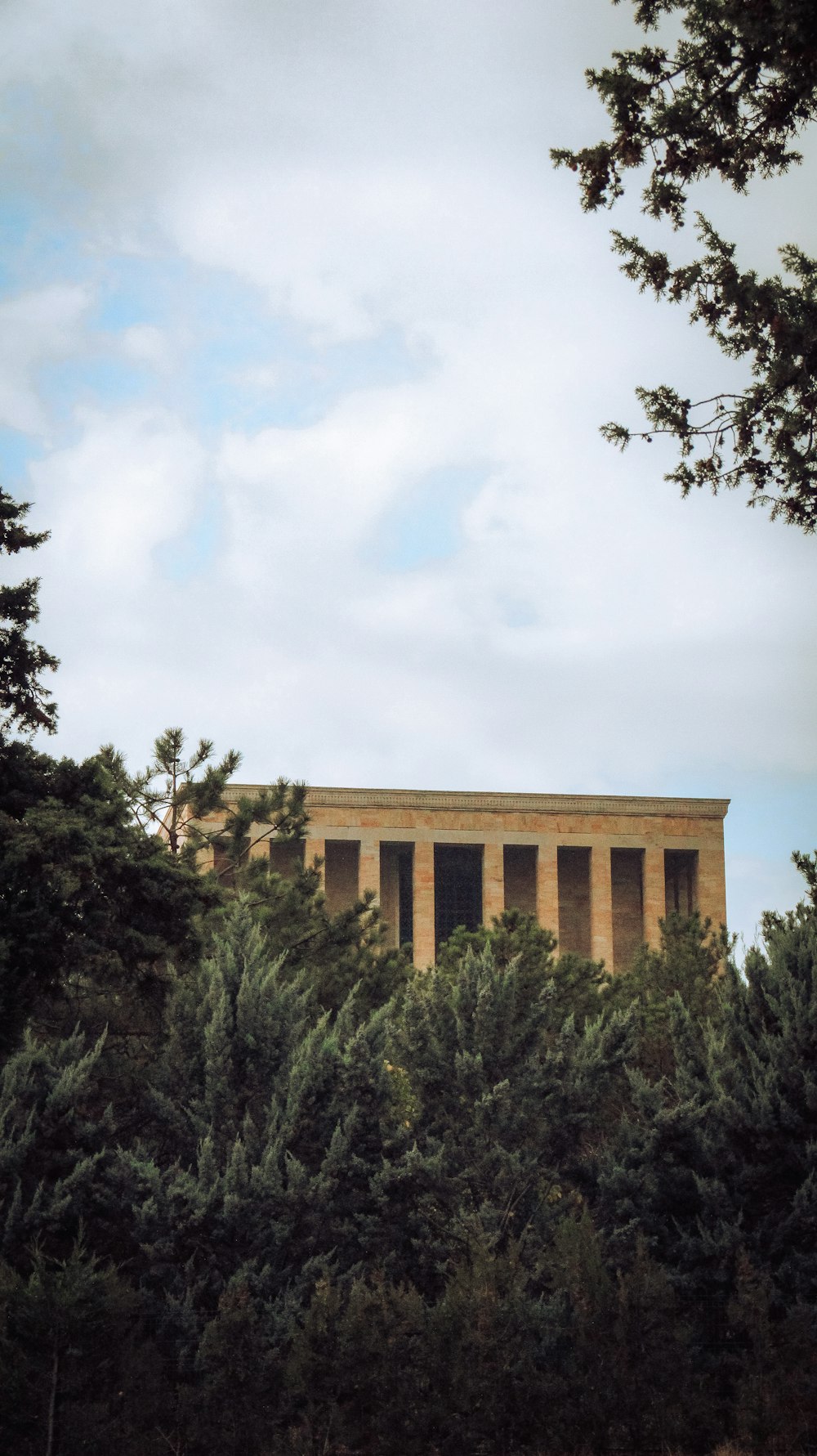 a tall building sitting on top of a lush green forest