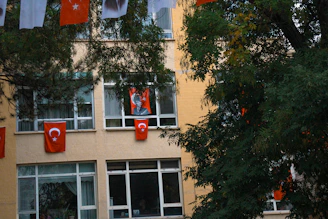a tall building with a bunch of flags hanging from it's windows