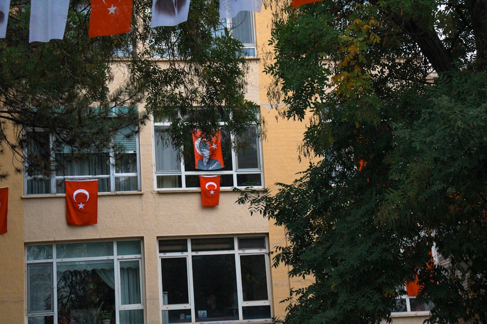 Ein hohes Gebäude mit einem Haufen Fahnen, die aus den Fenstern hängen