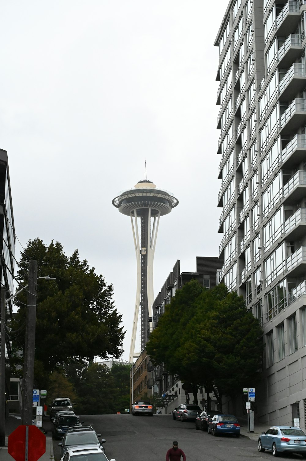 a man walking down a street next to tall buildings