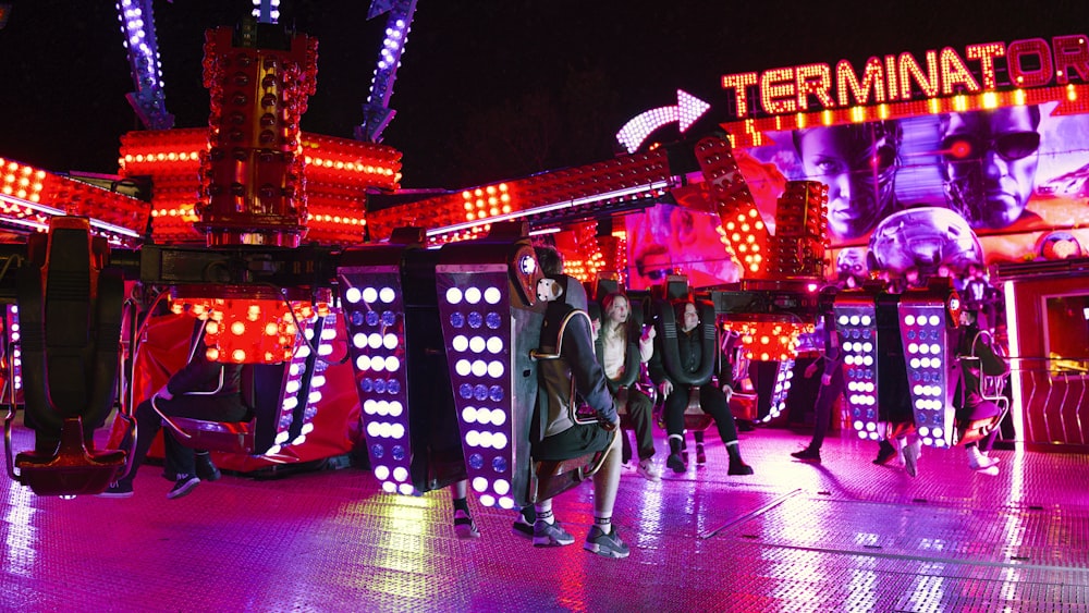 a group of people standing in front of a carnival ride