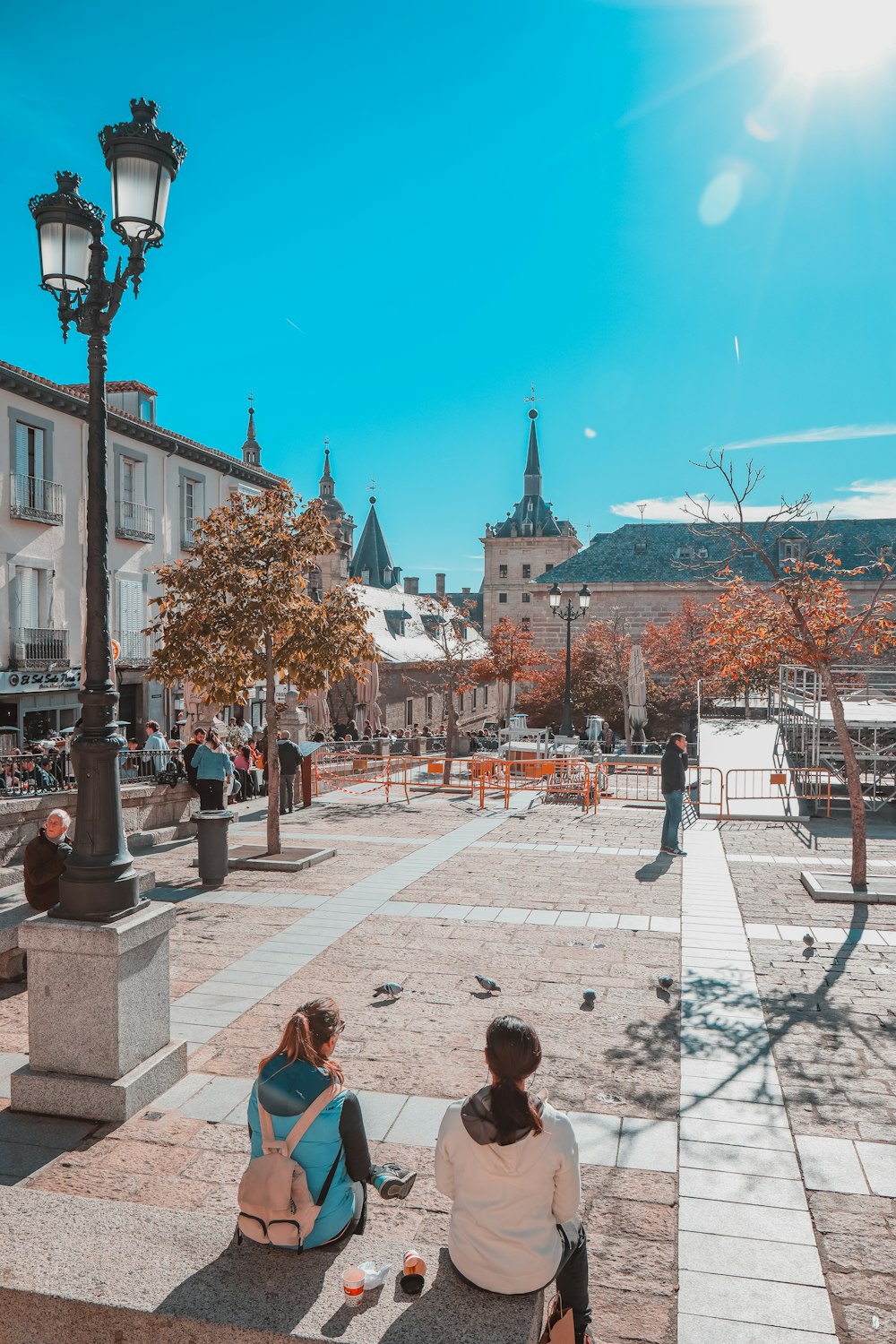 two people sitting on a bench in a plaza