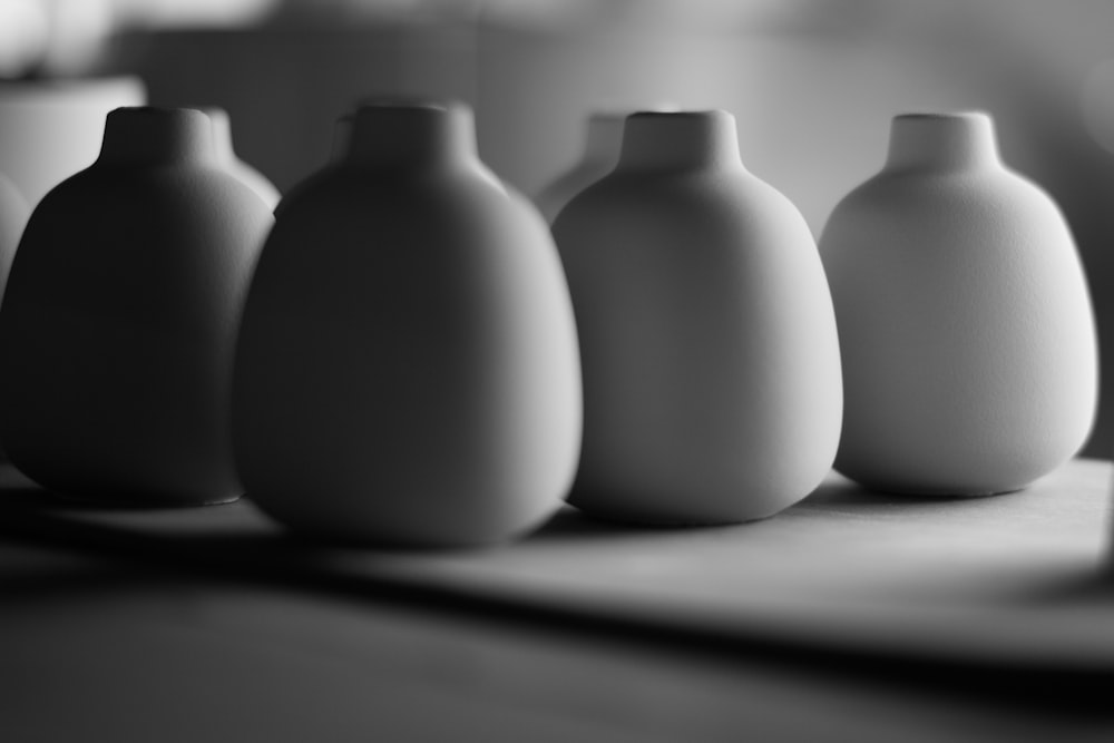 a row of white vases sitting on top of a table