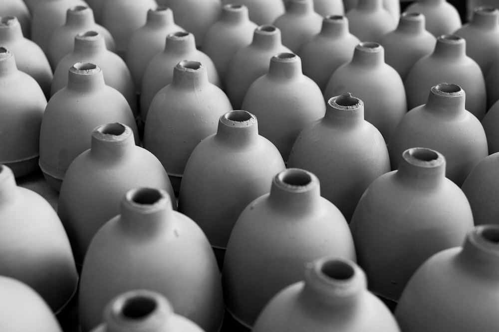 black and white photograph of many white vases