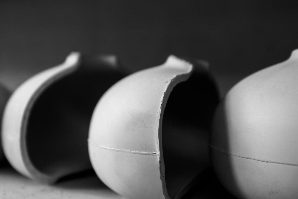 a row of white vases sitting on top of a counter