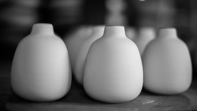 A collection of small, vibrant stoneware vases glowing softly in natural light.