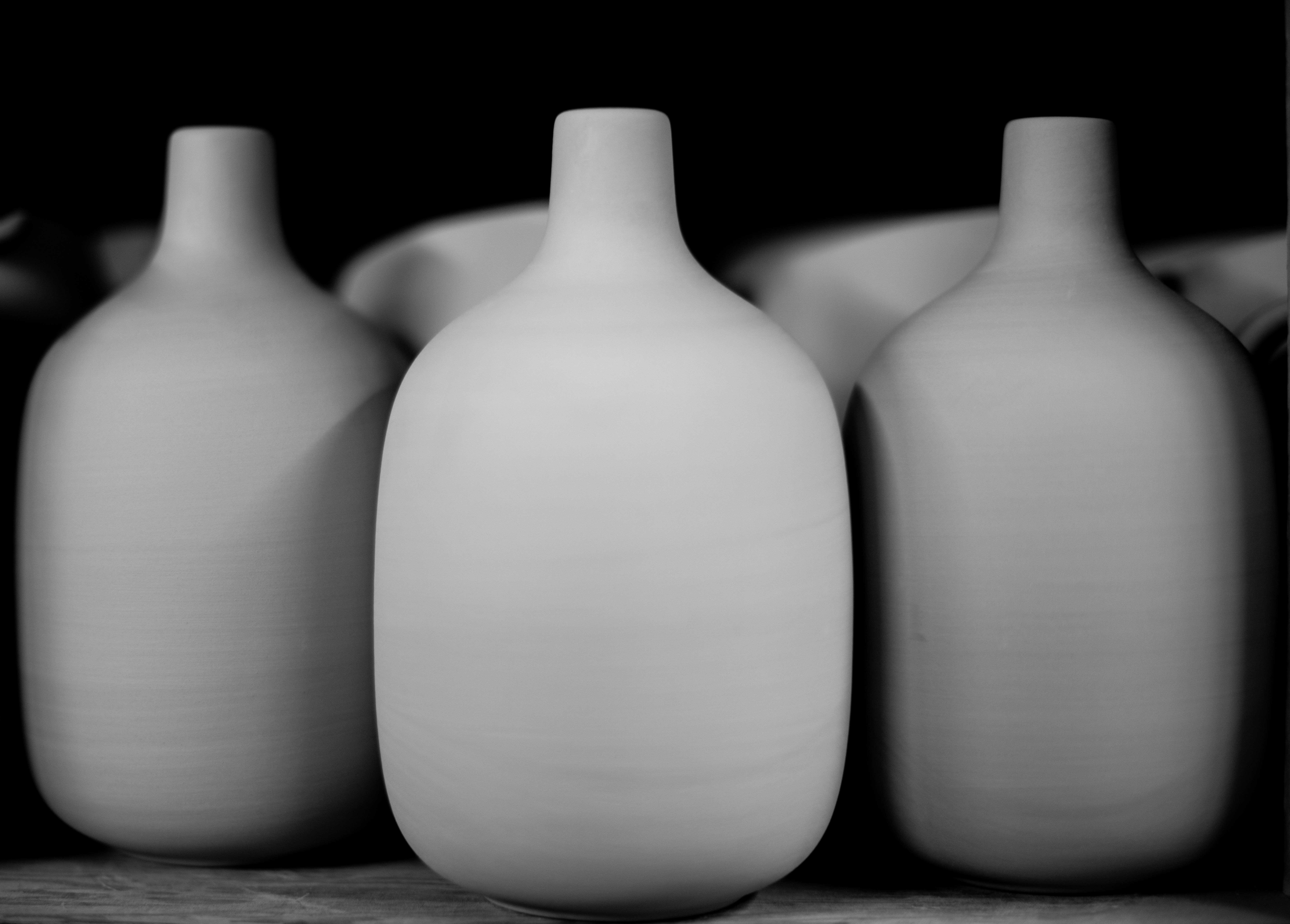 a group of white vases sitting on top of a table
