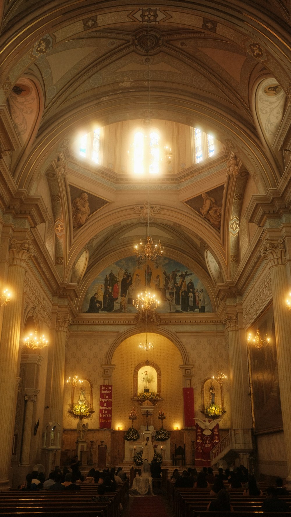 a church filled with lots of pews and chandeliers