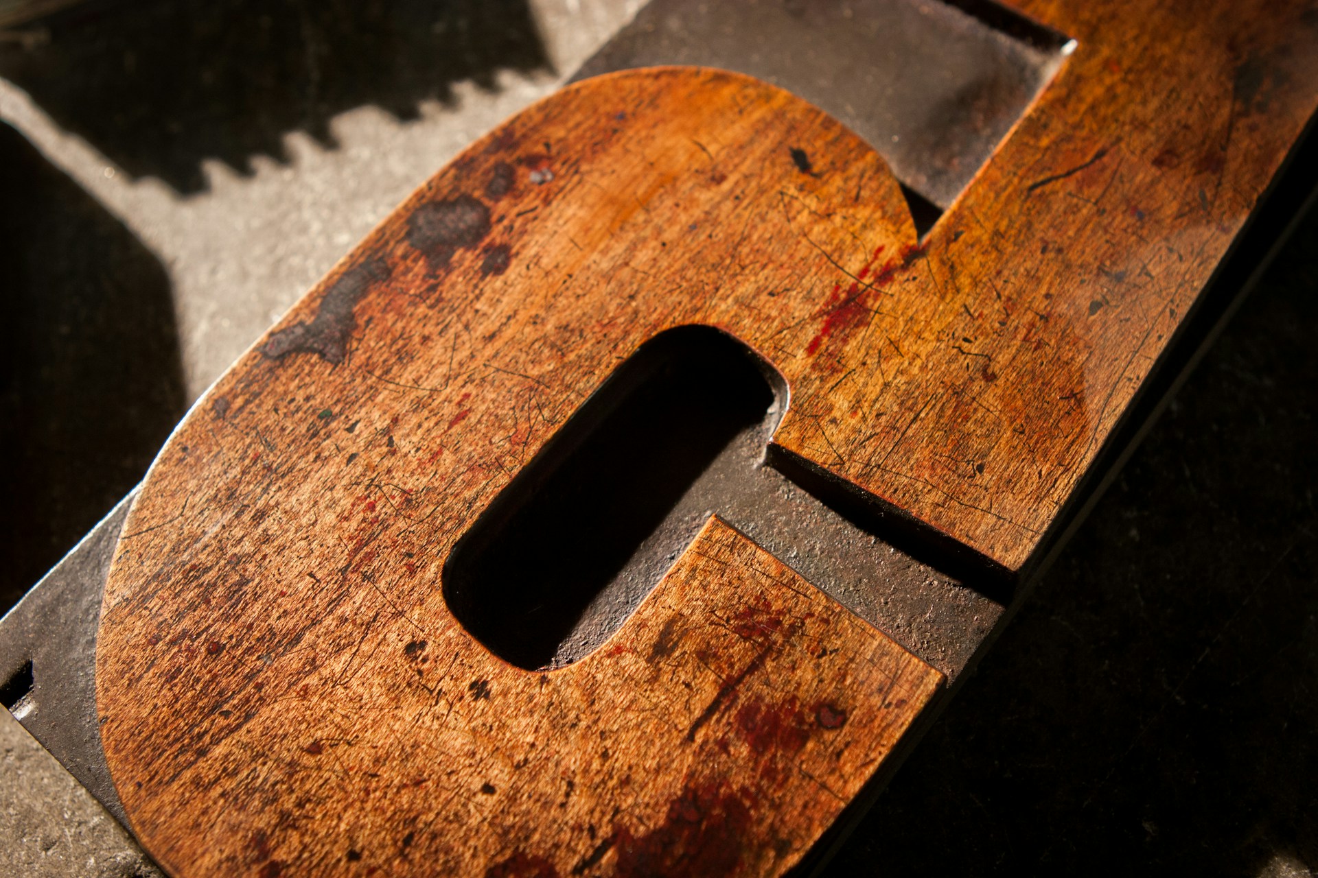 Close-up of a handcrafted wooden letter sign with elegant curves and smooth finish.