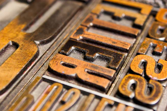 Close-up of a vintage letterpress machine printing Roman-style typography on textured paper.
