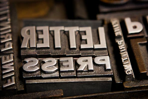 Letter Press stamp for the press company logo, brass, silver, all with stamps on it. 