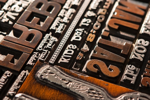 A close-up of vintage typesetting blocks arranged on a wooden table, capturing the essence of traditional printing.
