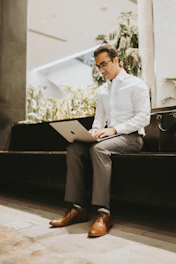 A professional portrait of Sachin Patade working on a laptop in a modern office setting.