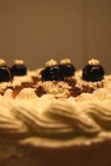 A close-up of an elegant multi-tiered cake adorned with fresh fruits and delicate chocolate decorations.