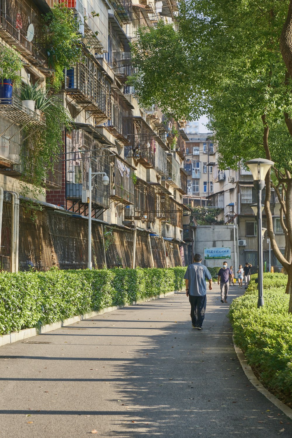 a man walking down a street next to tall buildings