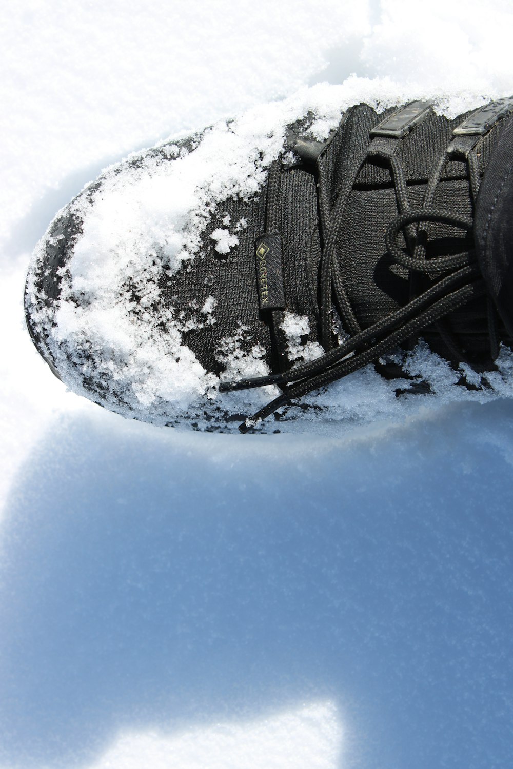 a person standing in the snow wearing a pair of shoes