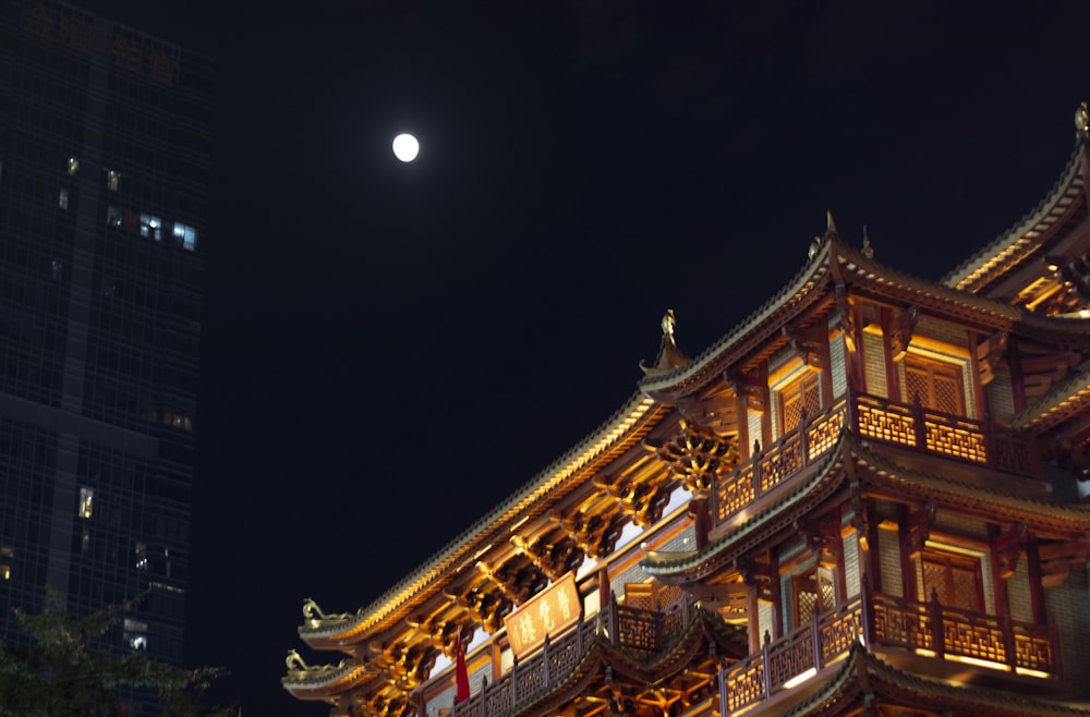 a tall building with a full moon in the background