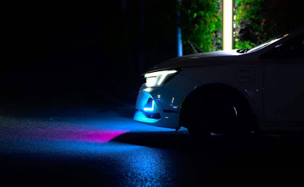 a car parked in the dark with its lights on