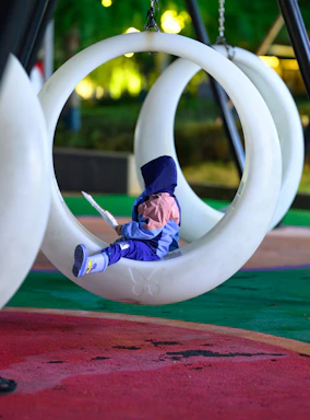 a small child is sitting in a tire swing