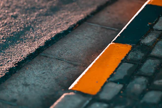 Close-up of a freshly painted curb with bright, clean lines on a sunny day.