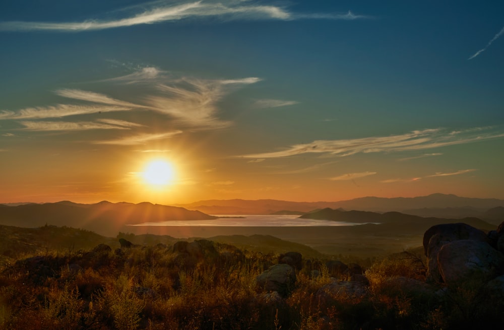 the sun is setting over a mountain range